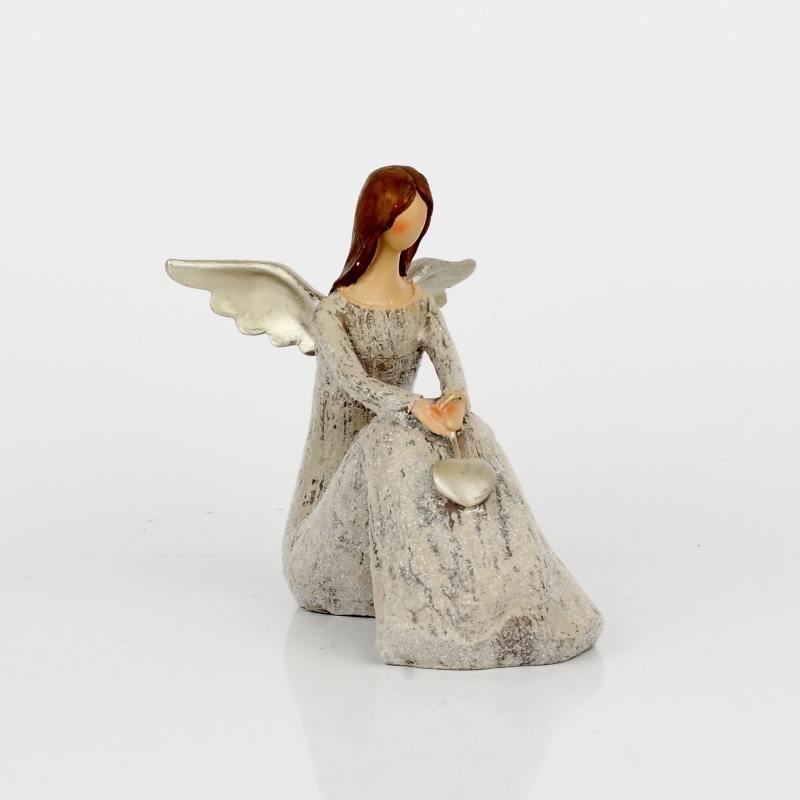 Anděl sedící se zlatými křídly a srdcem 