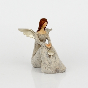 Anděl sedící se zlatými křídly a srdcem 