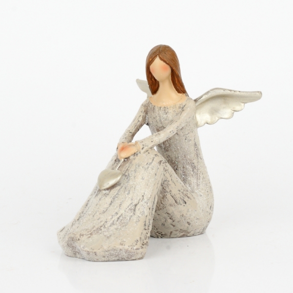 Anděl sedící se zlatými křídly a srdcem 