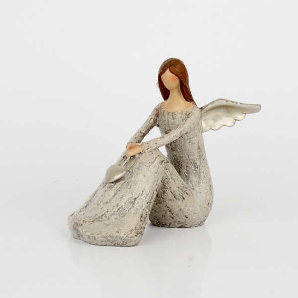 Anděl sedící se zlatými křídly a srdcem 